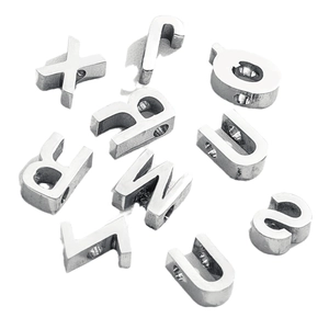 Polished silver stainless steel alphabet charms for DIY necklaces on white background
