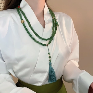 Long collier de perles en jade vert foncé avec ornements dorés et pompon en soie bleue