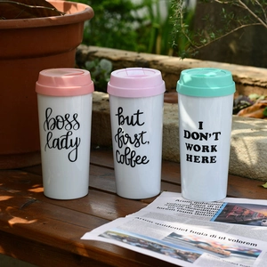 Three Boss Lady double-walled acrylic coffee cups in pink and mint green outdoor setting