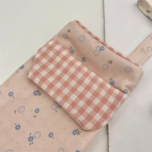 Close-up of pink floral nurse pocket organizer with red checkered flap detail