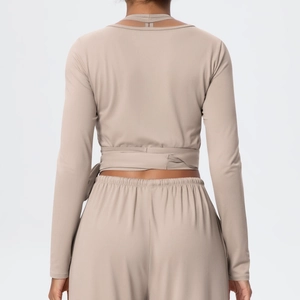 Detail of cross-tie back design on light brown yoga top with high-waist sports trousers