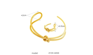 Detail view of gold knotted cuff bracelet and ring set with size measurements in cm