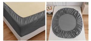 Detail of dark gray fitted sheet showing elastic corners and fabric texture for mattress