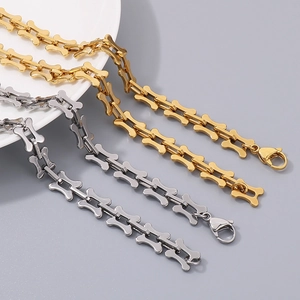 Gold and silver titanium steel hollow bone chain necklaces displayed on white plate