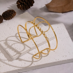 Makro-Detail des 18K vergoldeten Hohl-Armreifs mit Zirkonia-Steinen auf Steinbasis