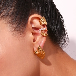 Close-up of irregular 18K gold-plated geometric stud and pearl ear cuffs on a model