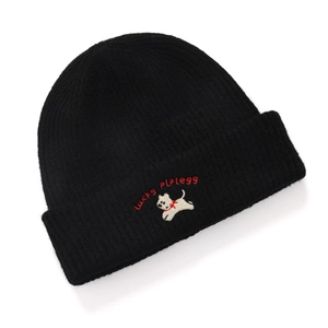 Close-up of black knitted winter hat with cute dog and Lucky letter embroidery