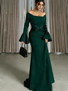 Detailed view of elegant off-shoulder dark green evening gown with dramatic bell sleeves