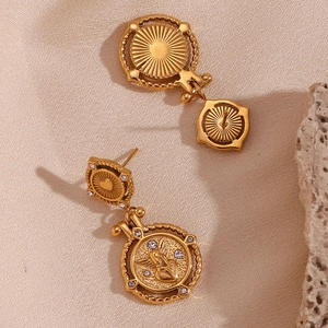 Detail view of retro 18K gold-plated coin earrings with angel heart and white rhinestones