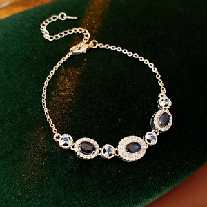 Detailed view of vintage silver bracelet with blue oval gemstones on green velvet