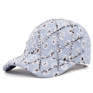 Close-up of rhinestone lattice and distressed denim fabric on light blue baseball cap