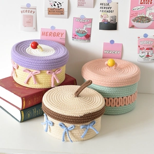 Detail of woven cotton rope storage baskets with lids and decorative bows for home decor