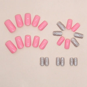 Faux ongles courts carrés rose avec des touches de paillettes argentées sur fond beige