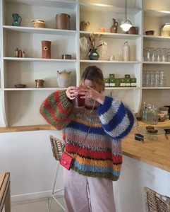 Close-up of rainbow striped knit sweater featuring chunky texture and colorful wool fibers