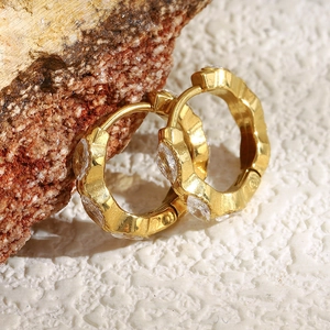 Detail of 18K gold-plated mini marquise zircon hoop earrings on a natural stone base