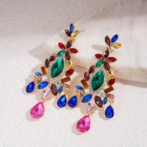 Close-up of vintage multi-color crystal chandelier earrings on marble surface