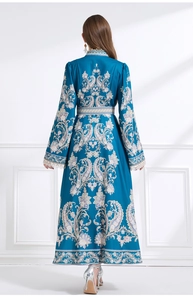 Vista posterior detallada de un vestido largo con estampado paisley azul pavo real en satén