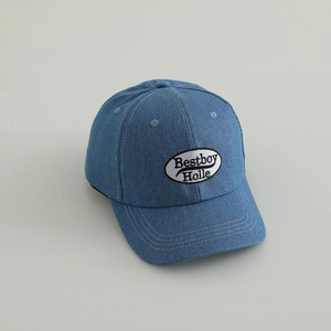 Detailed close-up of blue denim kids baseball cap with Bestboy embroidered patch