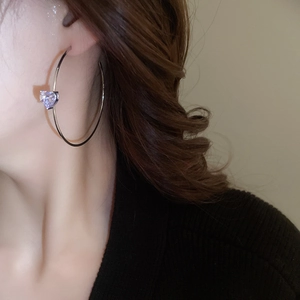 Détail d'une créole en argent en forme de C avec un zircon violet en forme de cœur