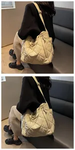 Detailed view of beige quilted tote bag showing diamond stitching and wide fabric strap