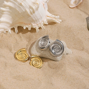 Orecchini a spirale a forma di conchiglia in oro 18 carati e argento sulla spiaggia