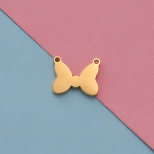 Close-up of golden bow-tie charm accessory with dual holes for DIY pet jewelry making