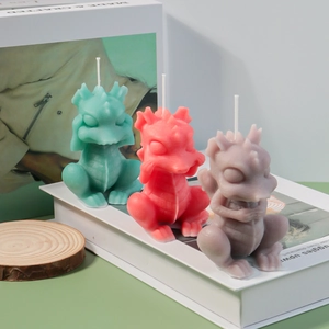 Three dragon-shaped aromatic candles in green red and purple on a wooden base