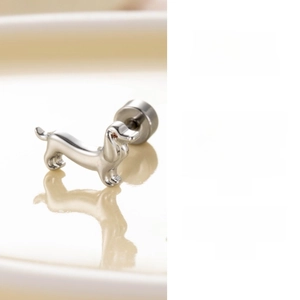 Macro detail of silver dachshund dog stud earring with polished metal and brown gem eye