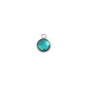 Macro shot of a 7mm round emerald green birthstone pendant with silver metal frame