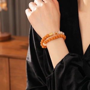 Detail of double-strand yellow bodhi seed bracelet with a carved golden metal bead