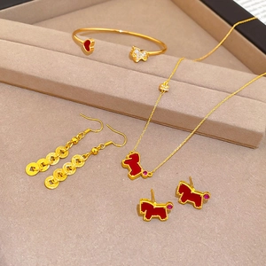 Detail of luxury gold jewelry set with red enamel horse charms and clear zircon stones