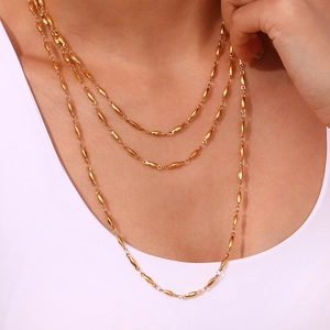 Detailed close-up of triple-layered 18K gold-plated stainless steel necklace on a model