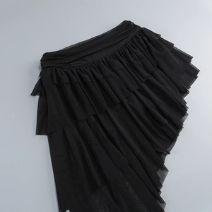 Detailed view of black multi-layered tulle skirt with ruffled texture and irregular hemline