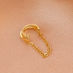 Goldene zweilagige C-Ohrmanschette mit Zirkon und Kette auf Champagner-Satin-Hintergrund