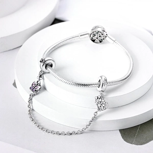 Silver snake chain bracelet featuring purple butterfly and hollow heart tree charms