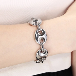 Close-up of a chunky silver stainless steel link chain bracelet worn on a wrist
