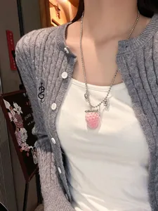 Close-up of pink flocked strawberry pendant on stainless steel chain with small charms