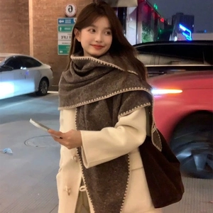 Chic dark brown winter shawl scarf with white stitched edges worn by a model at night