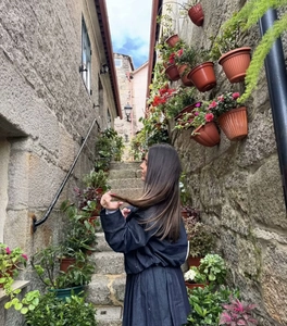 Detail view of a vintage dark blue denim jacket and pleated skirt on a scenic stone stairway