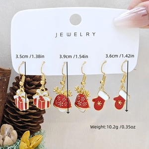 Detail of Christmas earring set showing sizes of gift box, polka dots and mitten charms