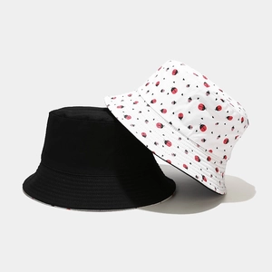 Detail of reversible bucket hats in black and white ladybug print with neat stitching