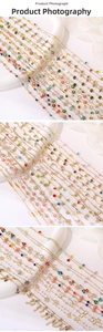 Detail of gold necklaces with colorful oil-dripped flowers, evil eye, and star charms