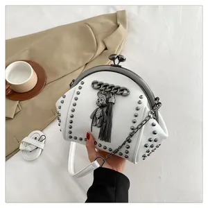 White rivet shell bag detail with metal clasp and diamond bear tassel charm