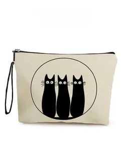 Detail of canvas makeup bag featuring three black cat silhouettes and secure zipper closure