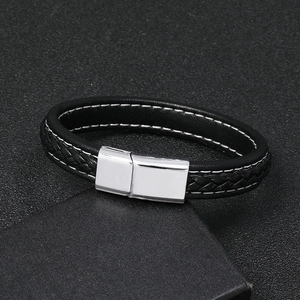 Detail of black braided leather bracelet featuring white stitching and silver magnetic clasp