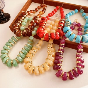 Vue détaillée de colliers en perles vintage de diverses couleurs sur un plateau à bijoux
