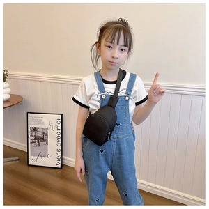 Close-up of minimalist black nylon kids chest bag with durable metal zipper detail
