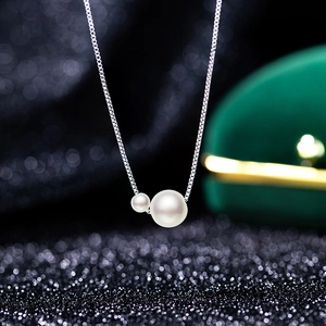 Elegant silver box chain necklace with dual white pearls on a dark luxury background
