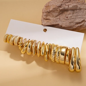 Vue détaillée d'un ensemble de 20 paires de boucles d'oreilles géométriques dorées sur carte
