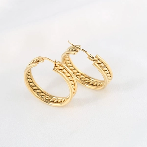 Elegant gold double-layered hoop earrings with vintage braided texture on white fabric